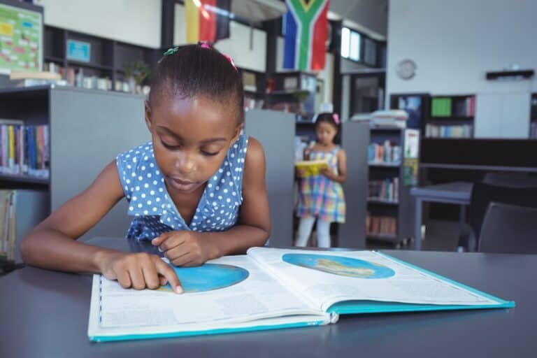 Girl reading book in library