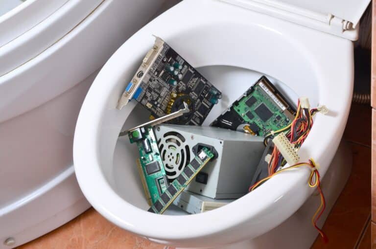 Old and unused computer details is recycled in toilet bowl. Metaphoric creative concept