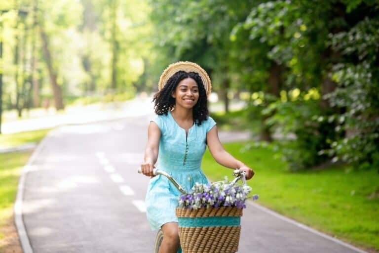 Young black girl going for ride on bike at beautiful green park in summer