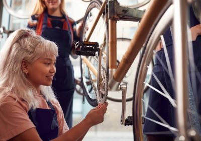 Female Team In Workshop Assembling Hand Built Sustainable Bamboo Bicycle